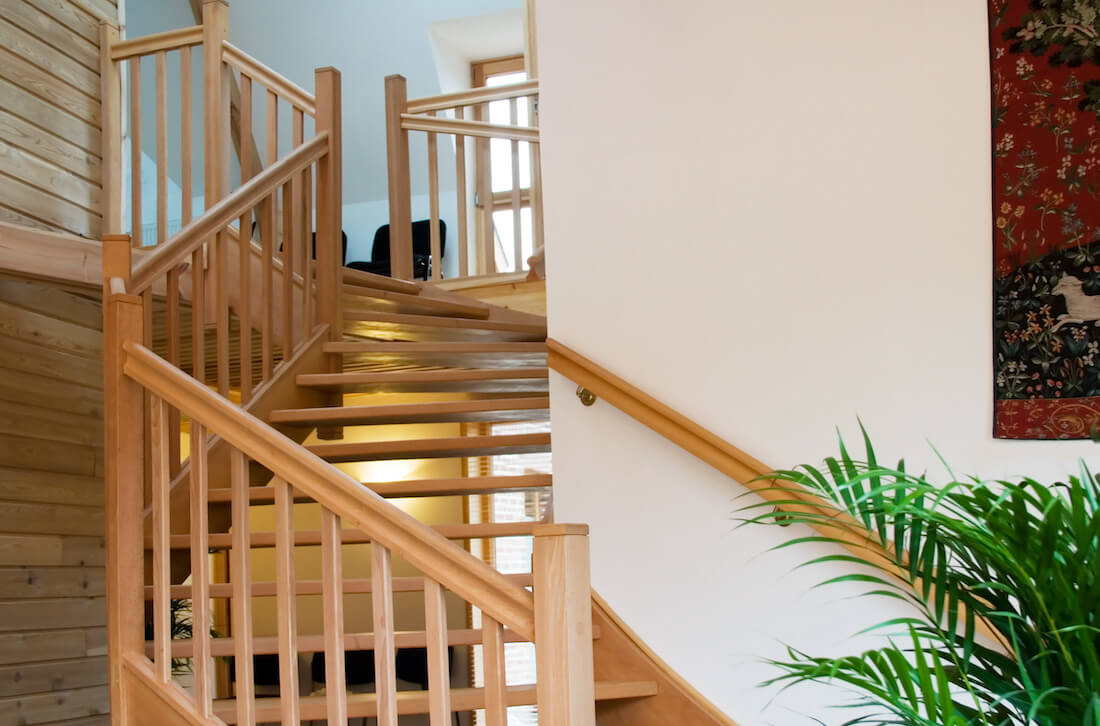 modern staircase with fern plant and tapestry